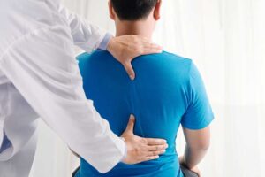 Person seated safely while a clinician performs a gentle balance and positional assessment.