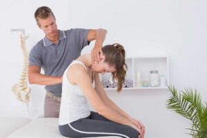 Person practicing gentle stretching beside a chair in a bright home living space.